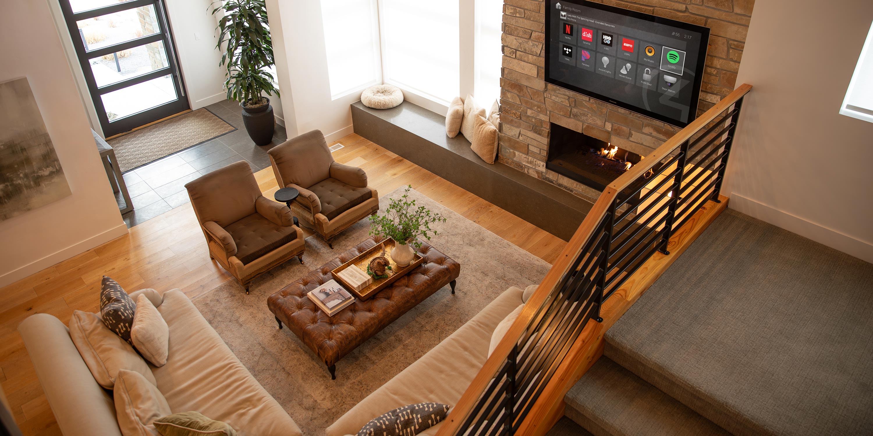 Cozy modern living room with fireplace, leather ottoman, and large windows